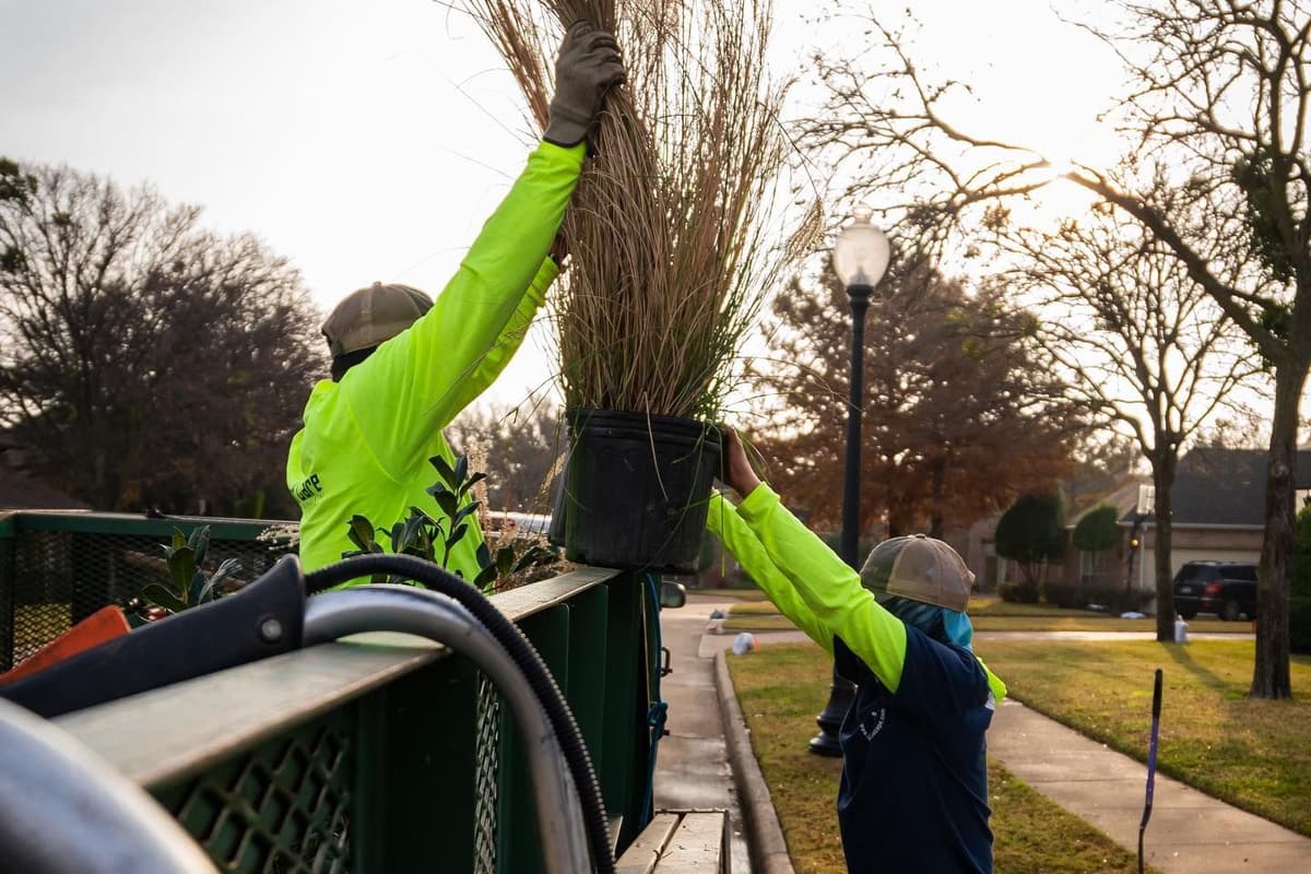 Maintenance crew edging beds and blowing walkways on a commercial campus