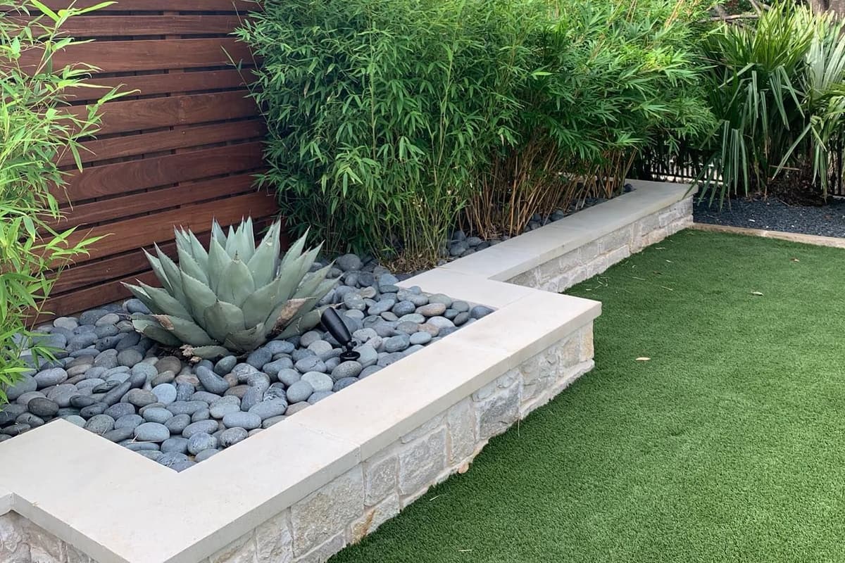 Curved stone seating wall wrapping a paver patio gathering space